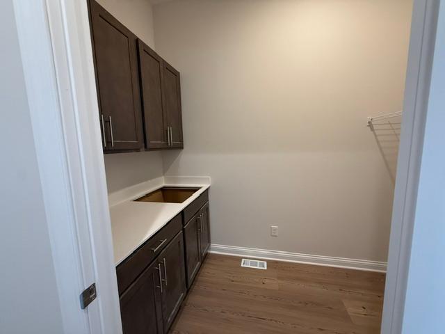 Spacious and well-organized upper-level laundry room designed for everyday ease, featuring ample space for folding, sorting, and storage.