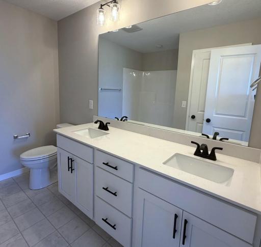 PHOTO OF A DIFFERENT HOME WITH SIMILAR PLAN. FINISHES MAY VARY. Primary Suite Private Bathroom features a Double Sink Vanity.