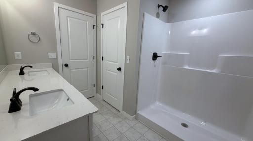 PHOTO OF A DIFFERENT HOME WITH SIMILAR PLAN. FINISHES MAY VARY. Primary Suite Private Bathroom includes a Linen Closet offering added storage.