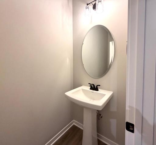 PHOTO OF A DIFFERENT HOME WITH SIMILAR PLAN. FINISHES MAY VARY. Main floor Half Bath features a pedestal sink.
