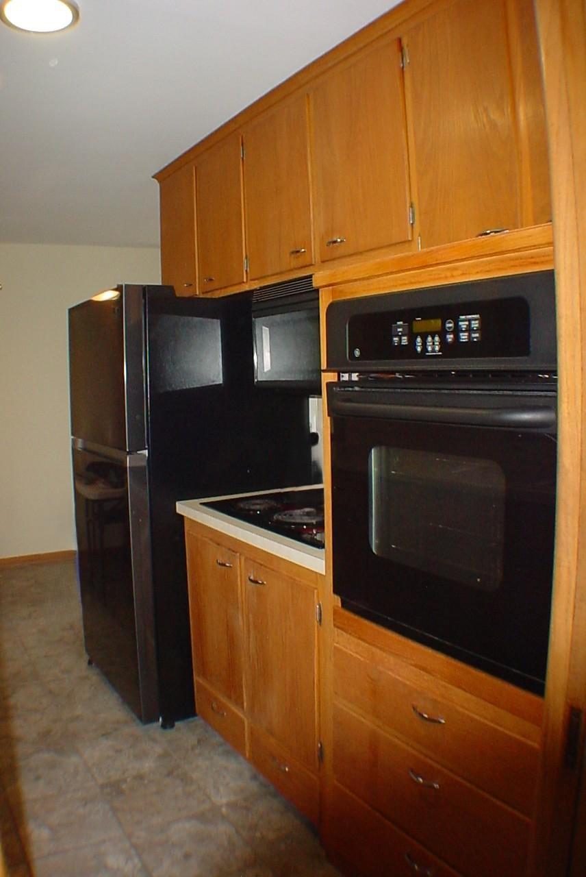Newer oversized fridge hosts plenty of fresh food storage space. It's amazing the storage a retro galley kitchen cabinet hosts.