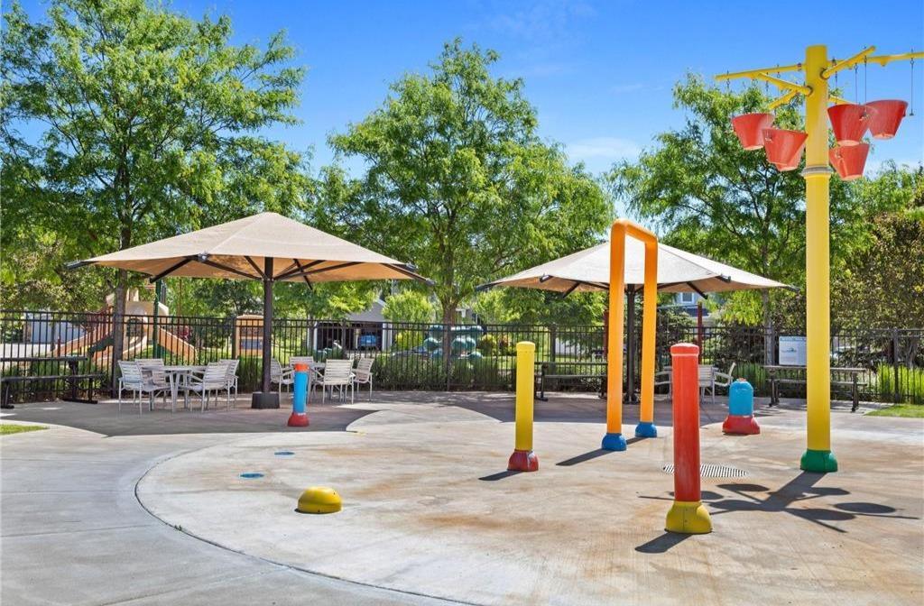 This fenced-in splash pad with umbrella seating offers a safe, shaded spot for kids to cool off and play.