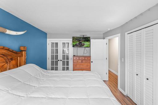 The connected bathroom from the primary bedroom is framed by elegant French doors