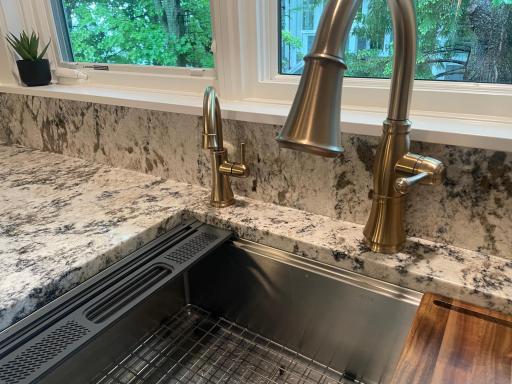 Deep and functional sink rests in the granite countertop. Water purification faucet and dedicated ice maker supply.