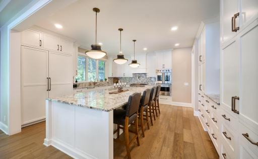 Custom cabinetry & high-end appliances: Cabinet-front Sub-Zero Refrigerator & Sub-Zero Freezer, Viking gas cooktop with griddle and a pot-filler, Viking professional dual-wall ovens.
