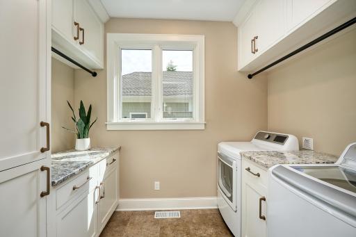 Laundry room just steps from the kitchen bosts custom cabinets, ample hanging space and spacious countertopsÂ 