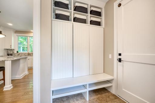 The garage entry is thoughtfully designed with shoe pull-out shelves and coat cubbies with storage for hats and gloves, offering easy access to the kitchen for everyday convenience.