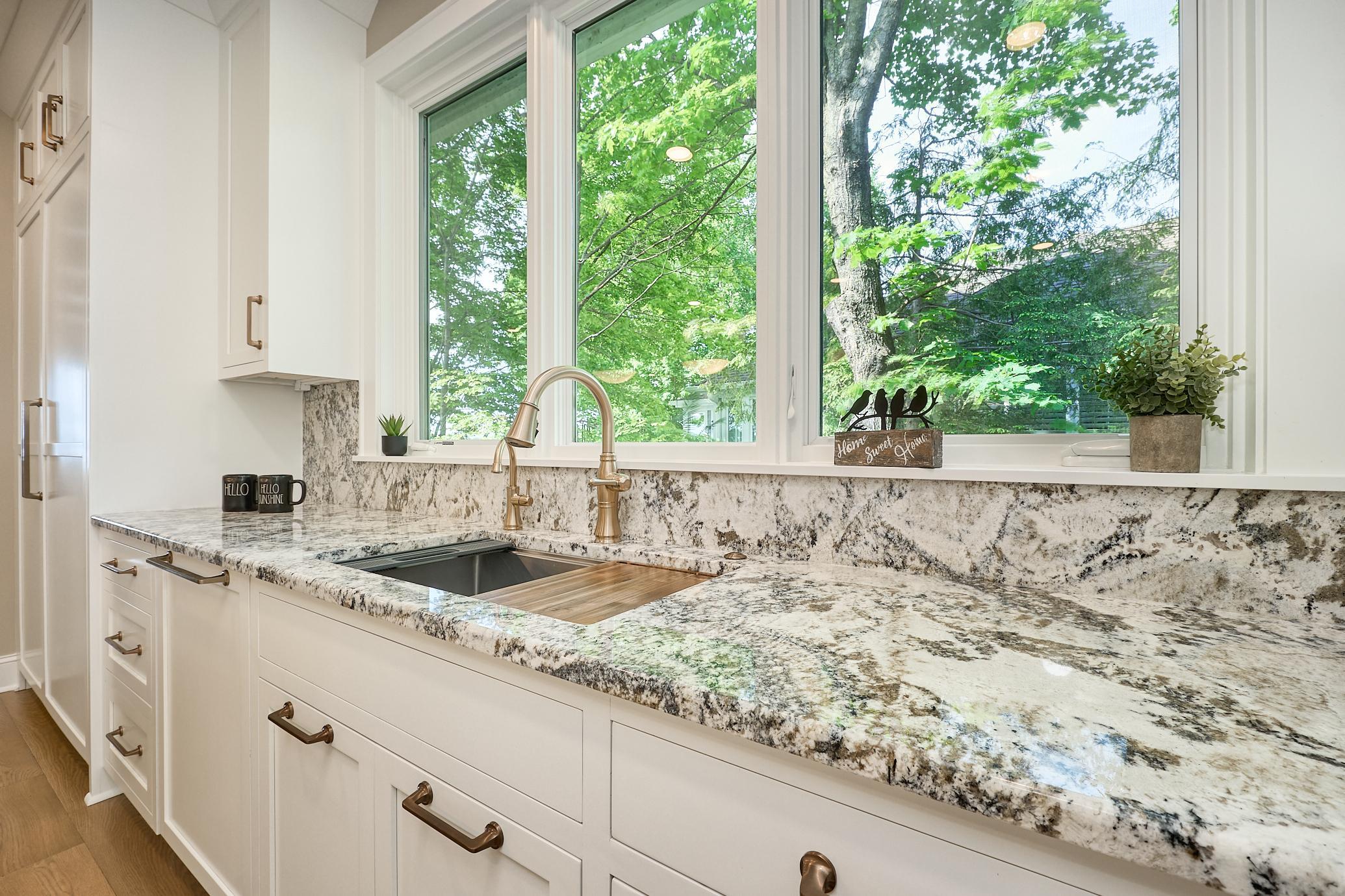 Abundant granite countertops, a custom panel-ready Bosch dishwasher, a Sub-Zero refrigerator and freezer with drawer and cabinet storage create a refined, highly functional west-facing wall designed for effortless entertaining and everyday elegance.