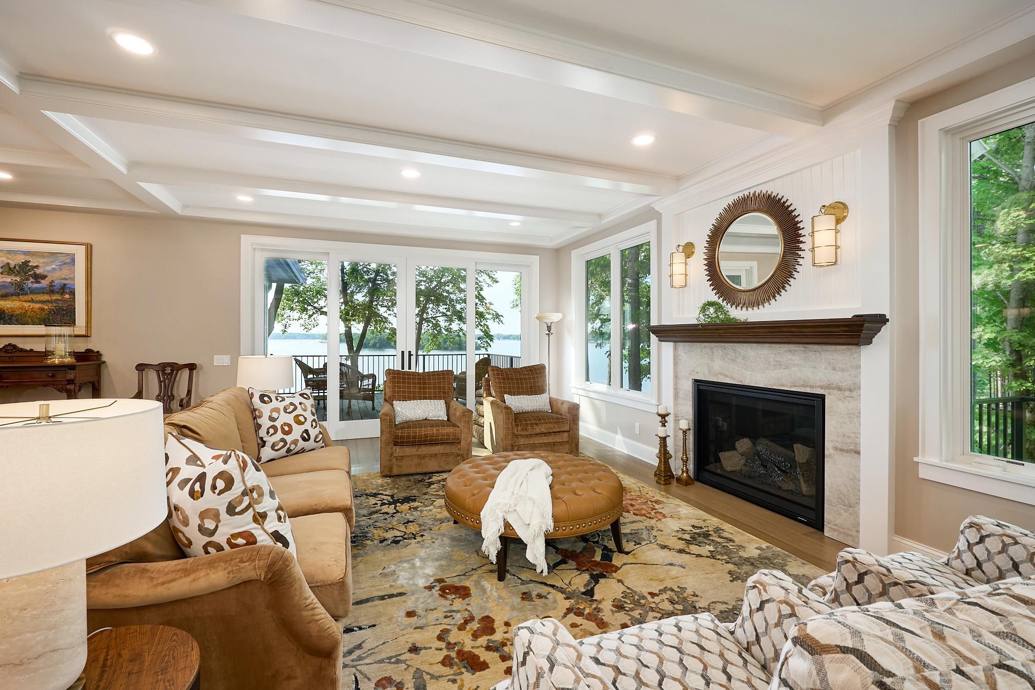 Relax in the living room by the gas fireplace and enjoy lake views through the new four-panel sliding patio doors.