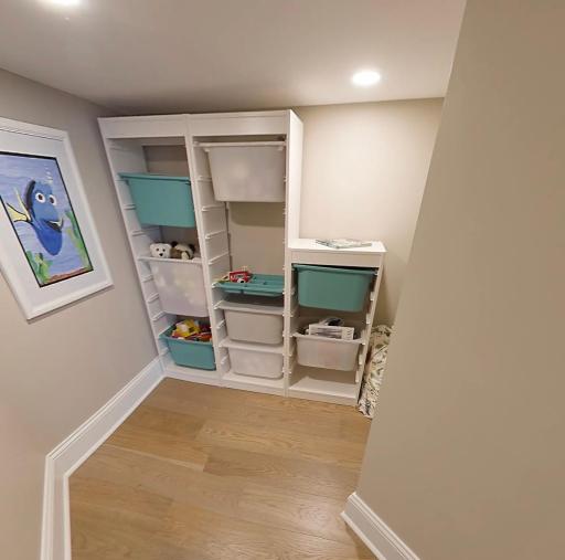 Enter through the concealed bookcase “secret door” to reveal a delightful children’s toy room tucked beneath the steps—a charming hidden space full of imagination and surprise.