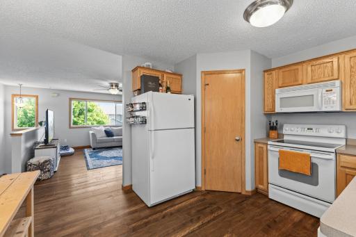 Open floor plan, viewed from the kitchen, warm tones for flooring, and plenty of natural daylight.