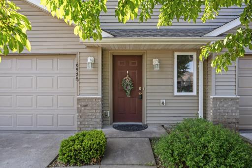 A warm, welcoming front door framed by soft lighting and natural textures creates an inviting first impression.