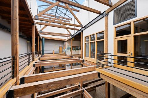 A light-filled atrium framed by exposed timber trusses and interior skywalks