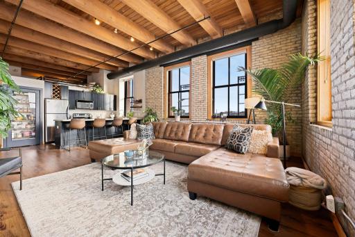 Soaring 14 ft tall ceilings with original wood beams and brick