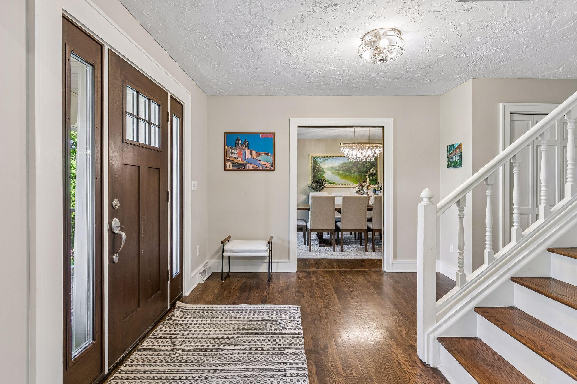 The home has an updated front door and sidelights. Hardwood floors are throughout the main level. To the left is a formal dining room.