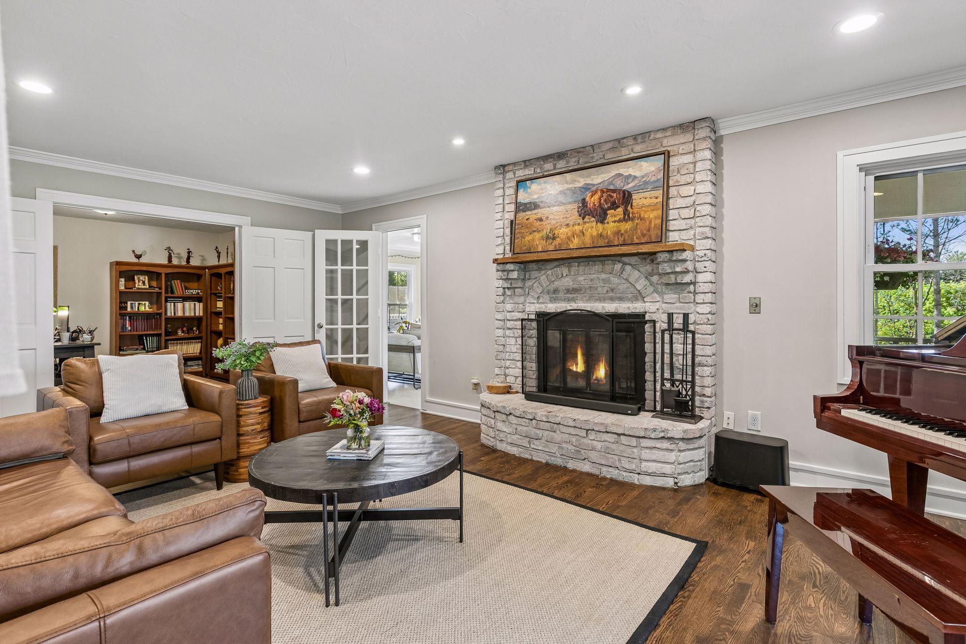 The living room has a brick fireplace with gas logs. Doors lead to a sunroom and study.