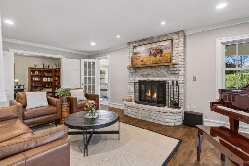 The living room has a brick fireplace with gas logs. Doors lead to a sunroom and study.