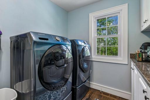 A full main-floor laundry room offers added convenience with built-in storage, while the primary closet includes a stacked washer and dryer.