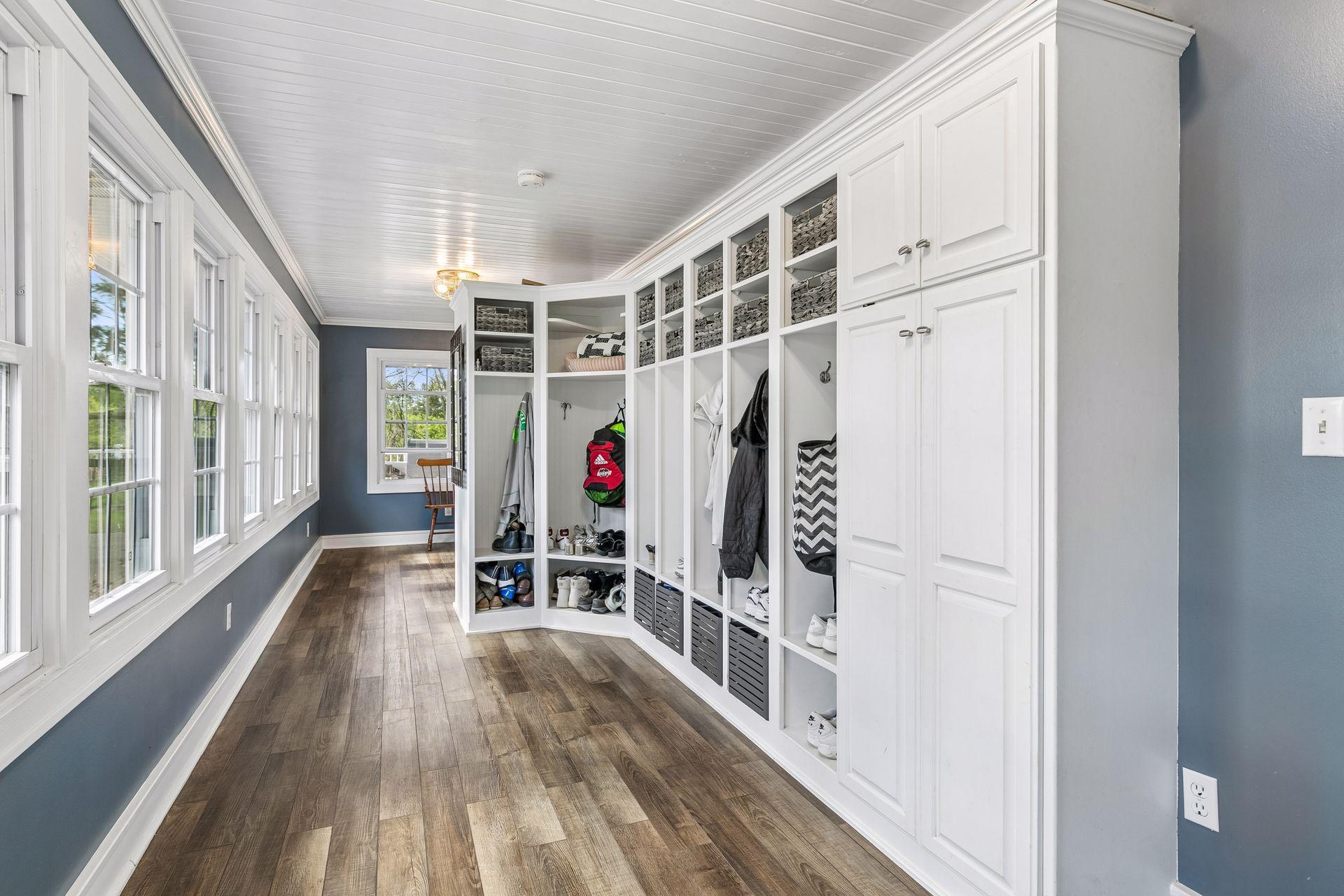 The long three-season porch has abundant storage. A door on the far end goes to the sunroom.