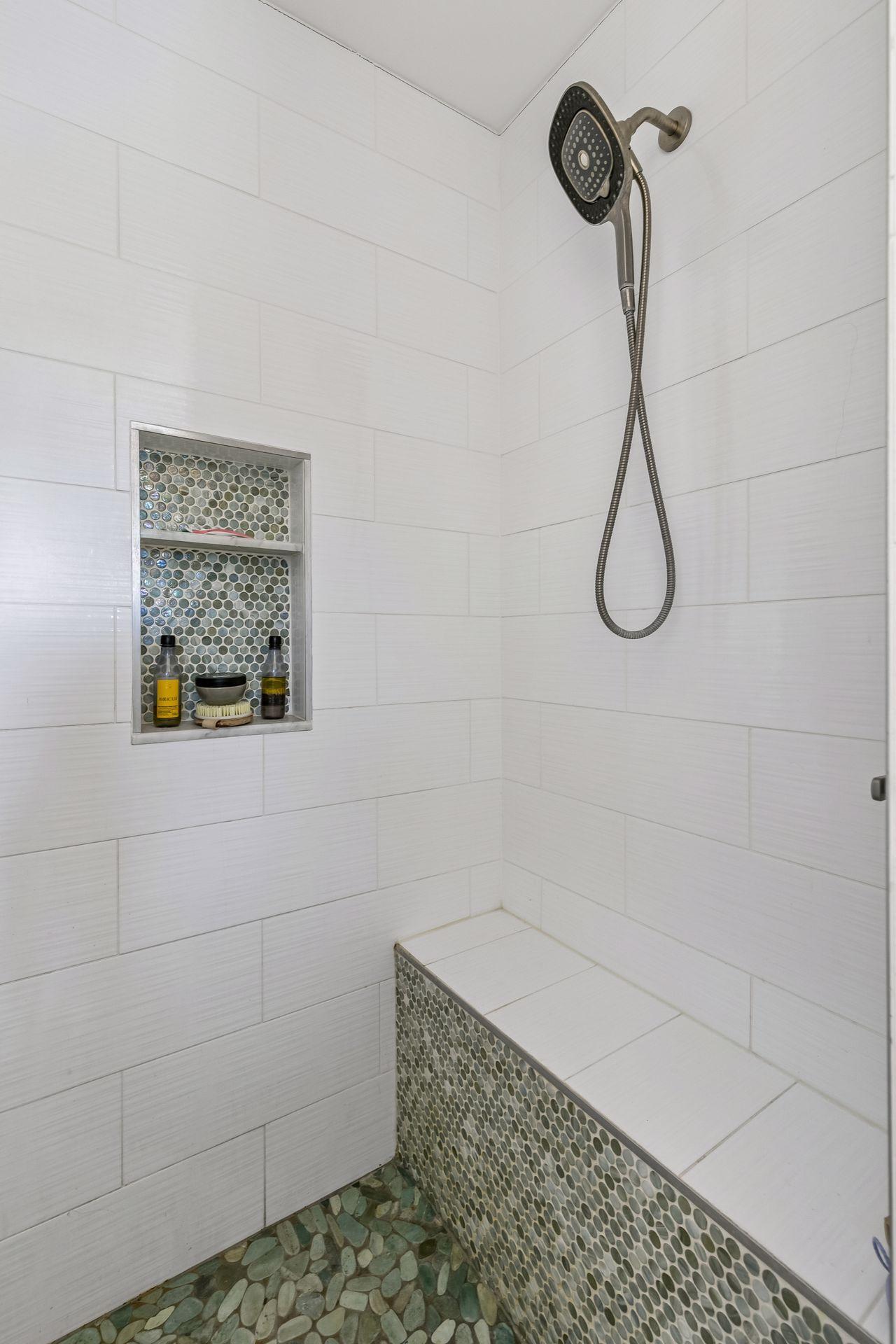 The bath has a custom tile shower and the primary closet has its own stacked washer and dryer for a second laundry.