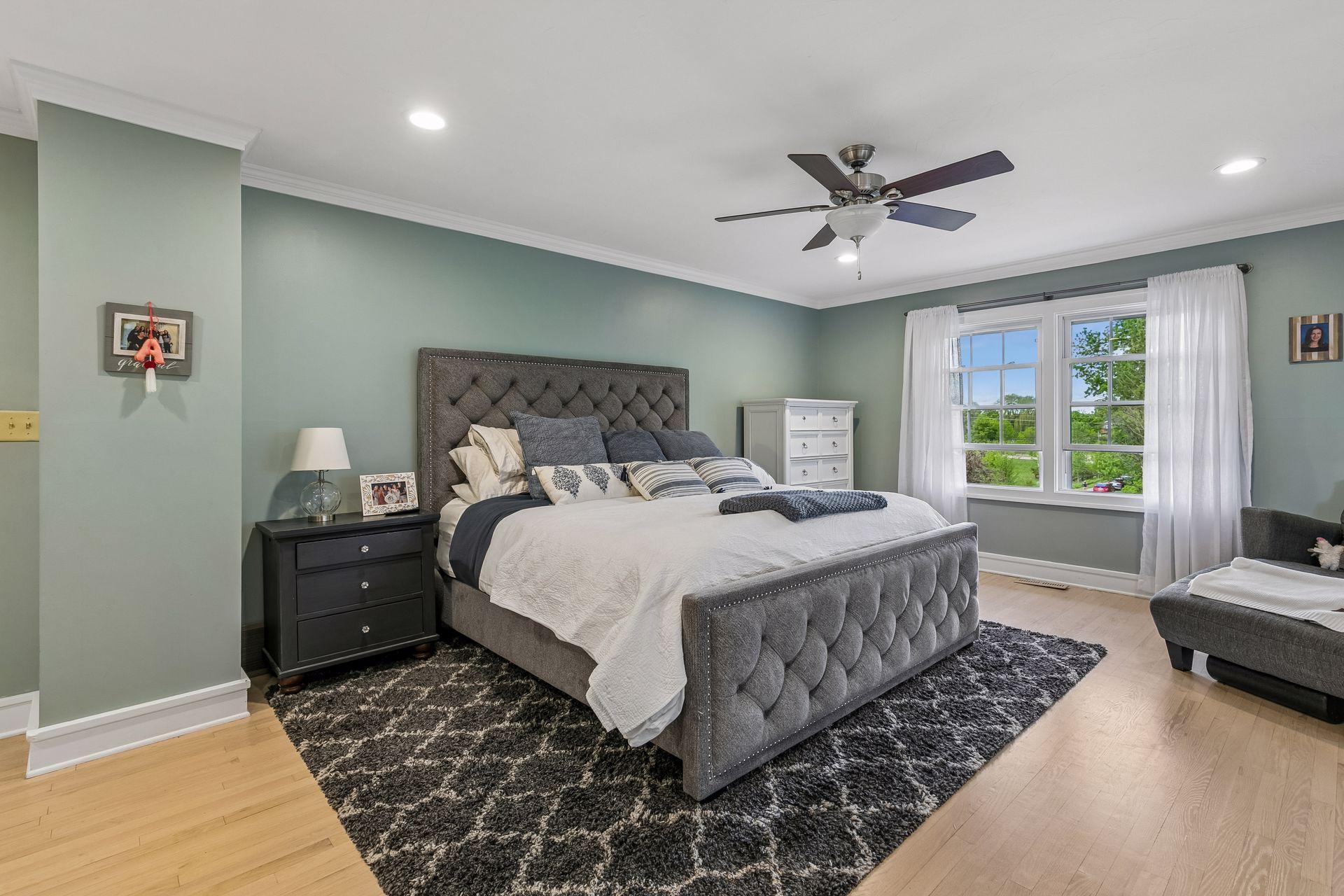 The room has crown molding with perimeter recessed lighting and a ceiling fan.