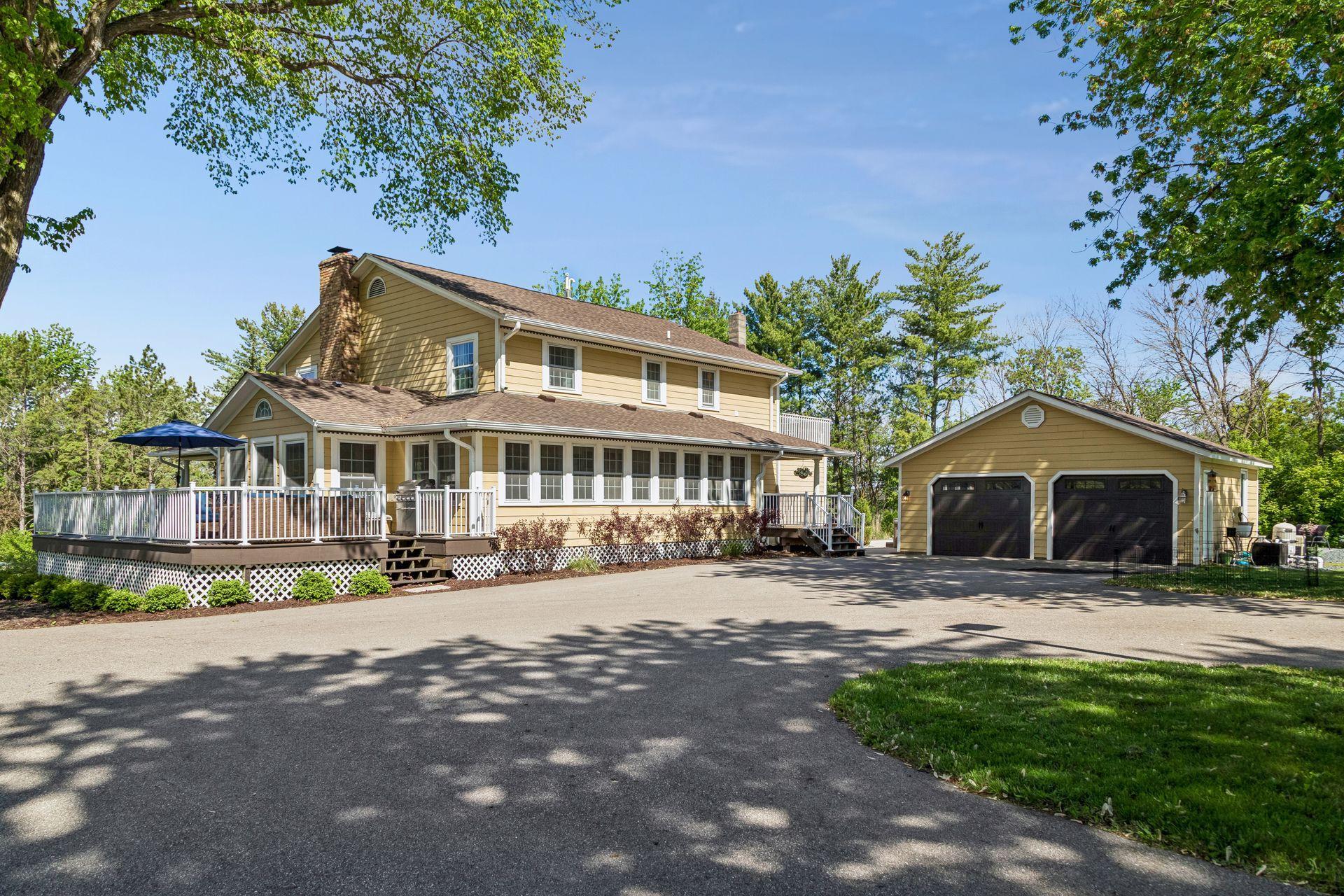 From the rear elevation of the home you can see the deck, three-season porch and detached garage.