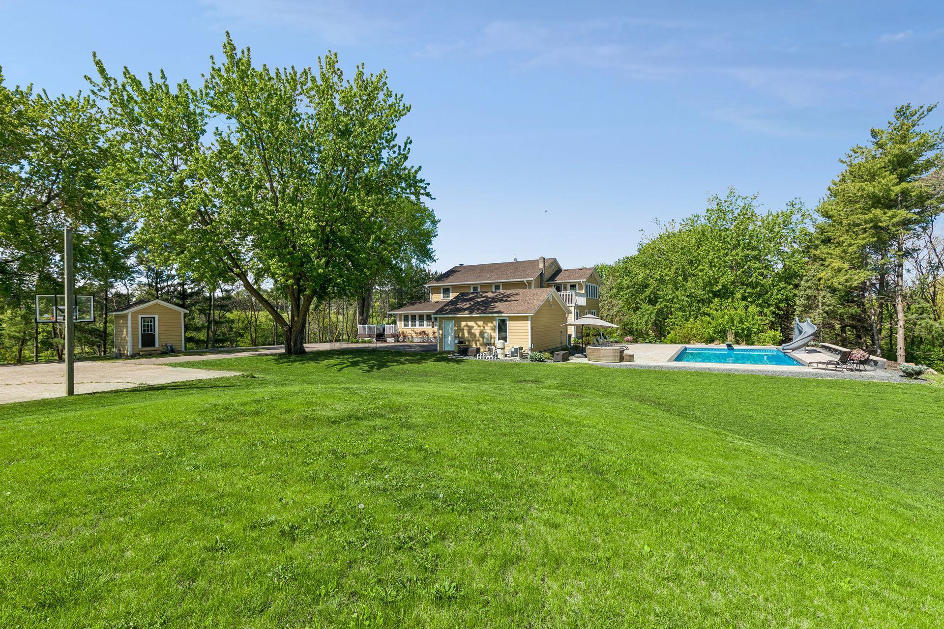 Behind the pool and garage is a large expanse of level lawn.