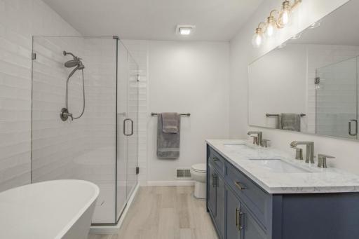 Nicely updated upper bathroom with large tub and shower along with stone countertops and tile.