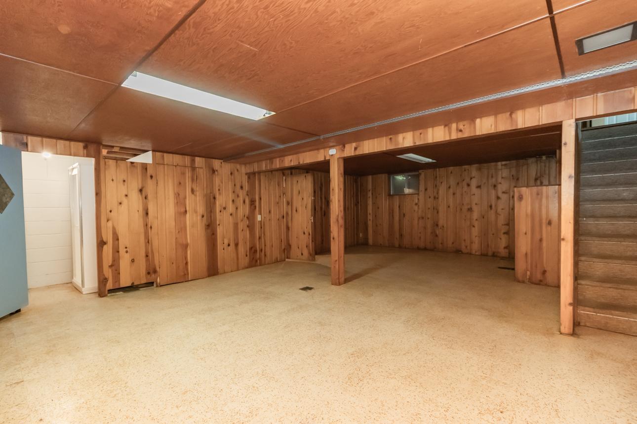 Spacious lower-level family room with wood-paneled walls and flexible layout for entertaining, hobbies, or additional living space.