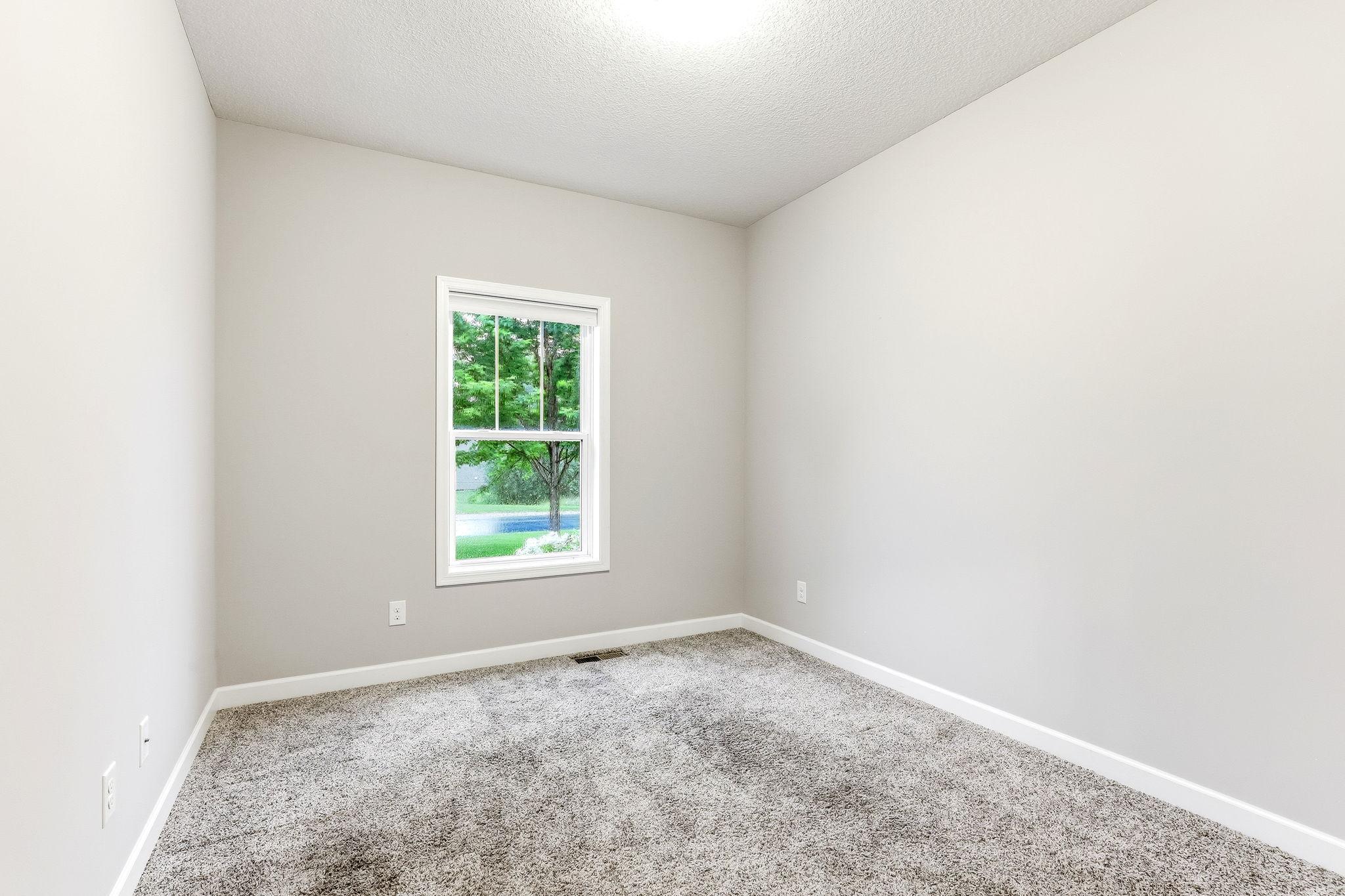 A bright and comfortable third bedroom on the main level.
