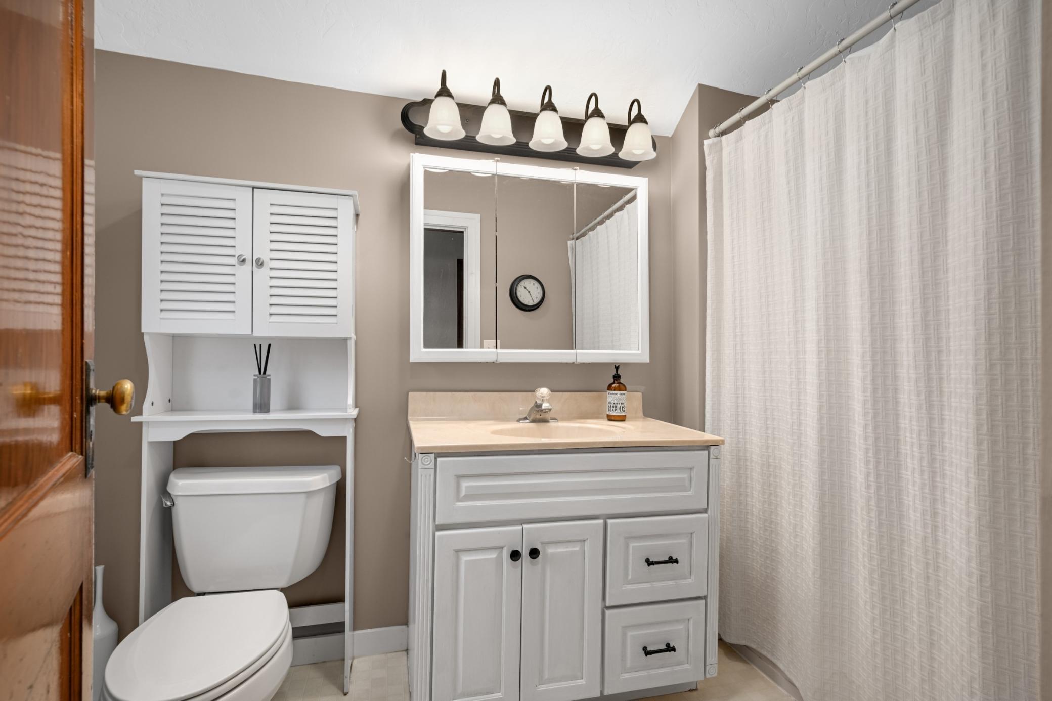 Upper level full bathroom with updated vanity. Window over-looking the private backyard.