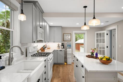 Tons of natural light in this kitchen with quartz countertops, stunning cabinets with under cabinet lighting