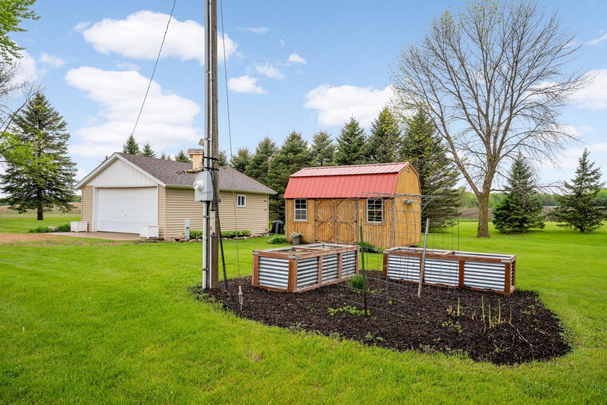 Garden with raised garden beds and storage shed with 2 car garage.