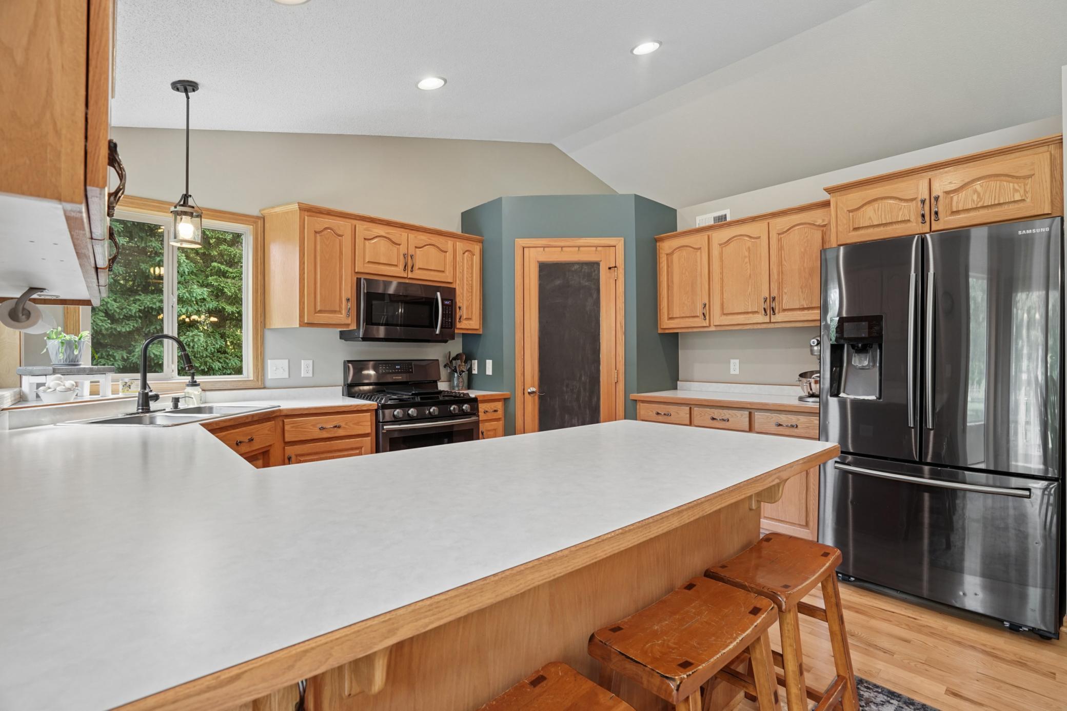 Corner sink with captivating backyard views, pantry, and a convenient breakfast bar counter for extra barstool seating