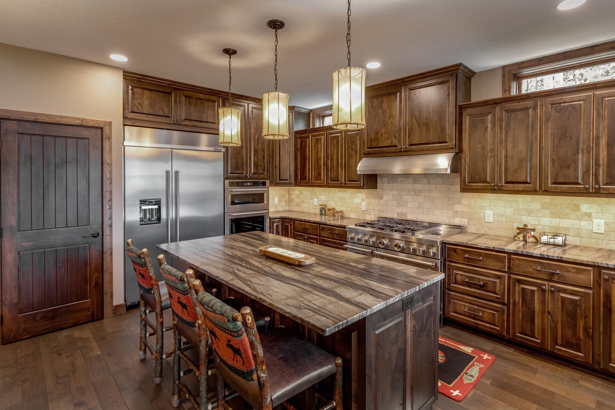 Modern finishes meet functional design—stainless steel appliances and a stylish island ready for your next meal.