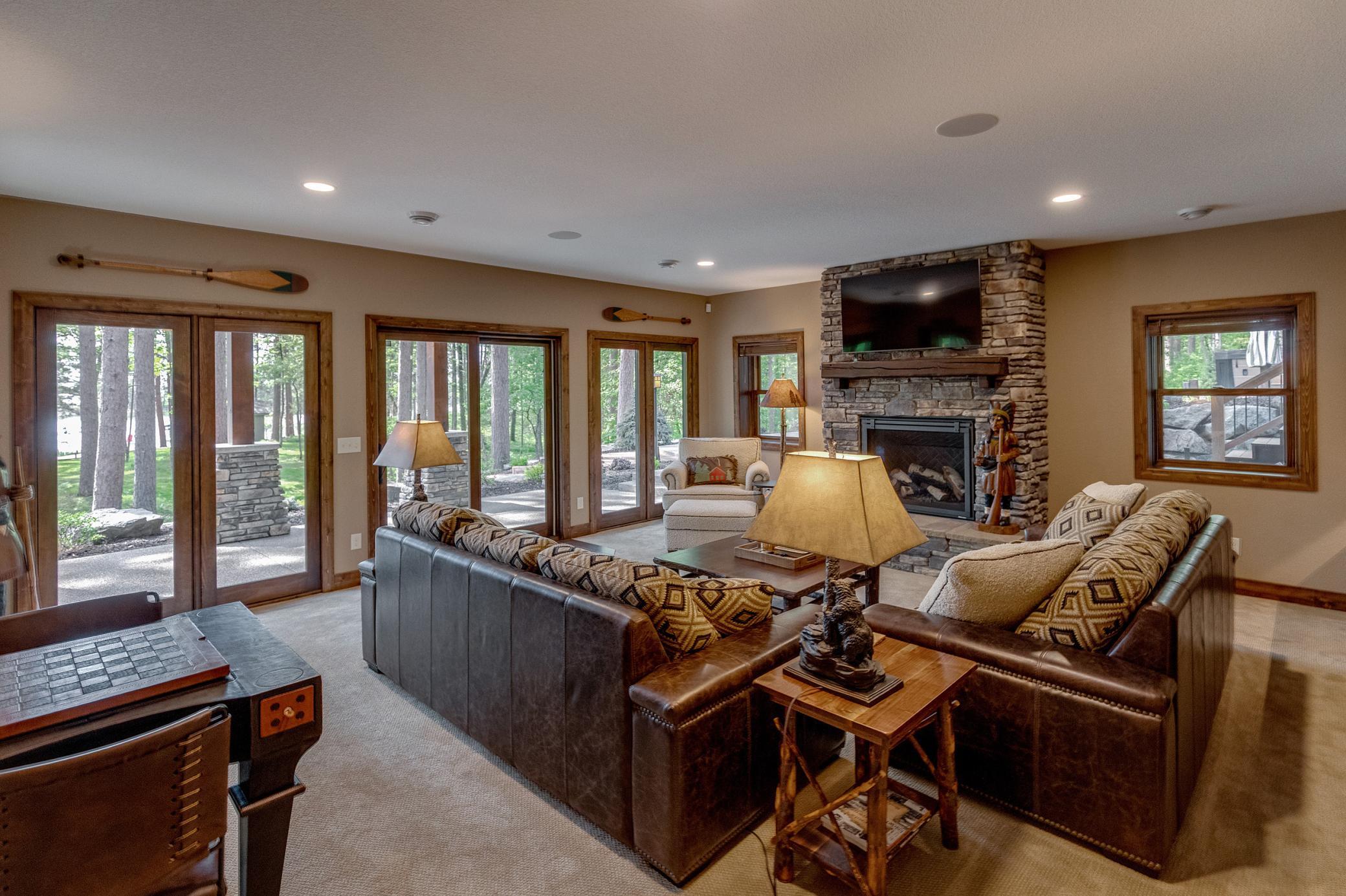A welcoming downstairs Family Room with big windows, patio doors, and a beautiful stone fireplace—perfect for relaxation and entertaining.
