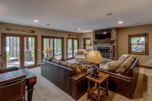 A welcoming downstairs Family Room with big windows, patio doors, and a beautiful stone fireplace—perfect for relaxation and entertaining.