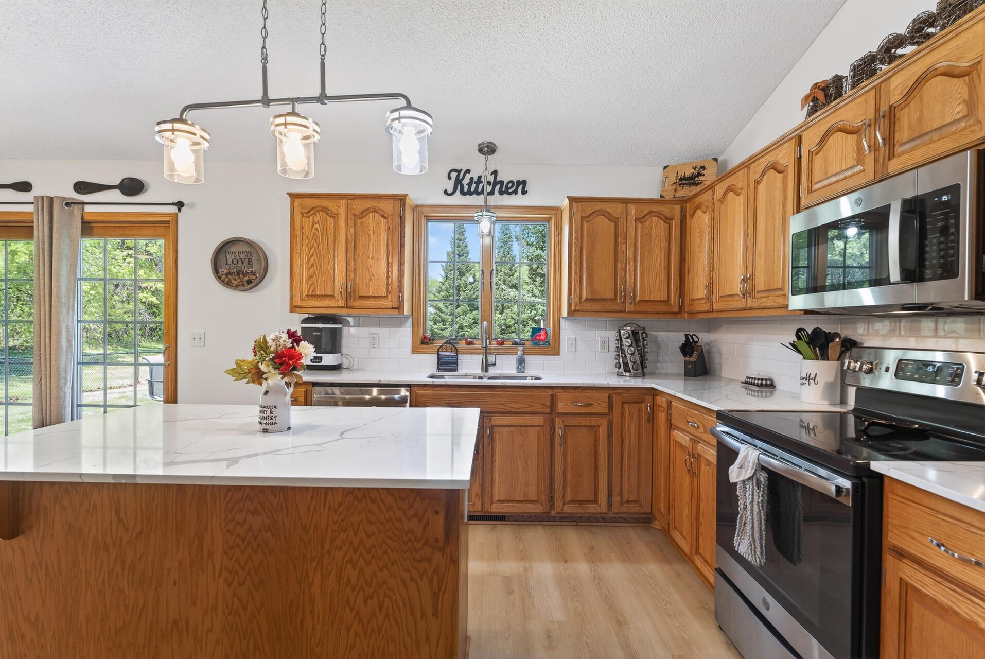 Solid-surface countertops and stainless appliances.