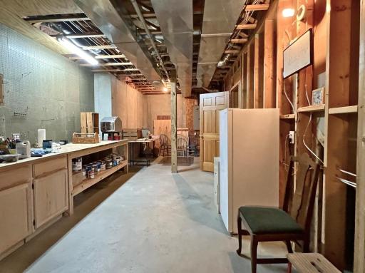 Poured cement foundation, basement w/high ceilings, work area, and plentiful storage