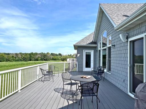 Spacious deck offering sweeping views of the golf course, mature woods, and surrounding natural landscape