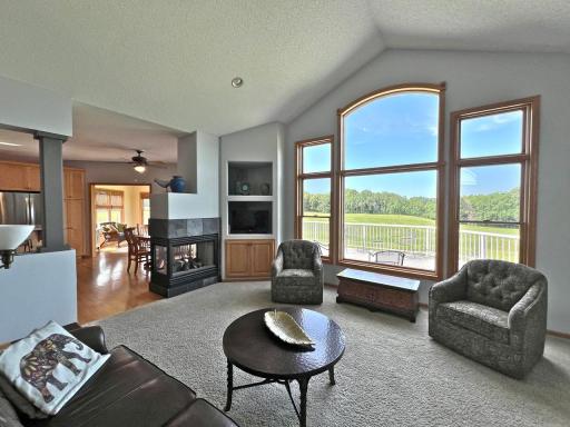 Inviting sitting area framed by oversized windows overlooking the deck and scenic golf-course setting