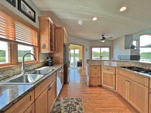 Kitchen view highlighting the center island, abundant cabinetry, hardwood floors, and convenient access to the deck