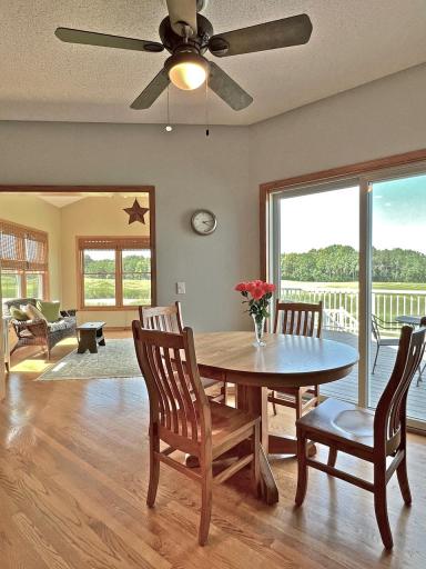 Informal dining area featuring hardwood floors, a ceiling fan, deck access, and expansive outdoor views
