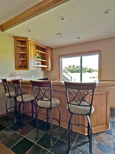 Custom lower level bar area in walkout lower level with views of golf course and rolling hills