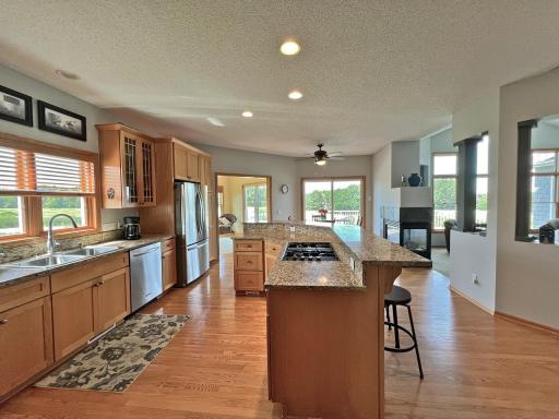 Well-appointed kitchen featuring extensive wood cabinetry, granite countertops, a center island, and open sightlines