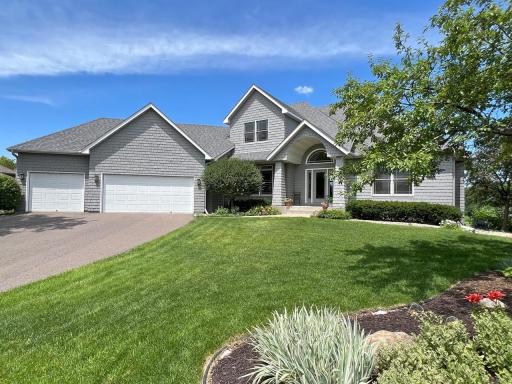 Welcoming front exterior featuring a three-car garage, manicured landscaping, and distinctive architectural details