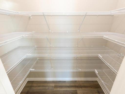 PHOTO OF A DIFFERENT HOME WITH SIMILAR PLAN. FINISHES MAY VARY. Kitchen Walk-in Pantry features shelving on three walls offering an abundance of storage.