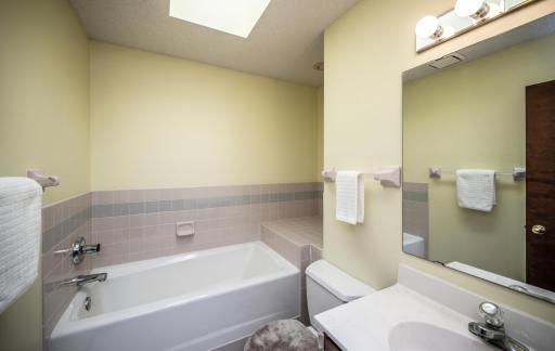 Hall bath features an extra deep and larger soaking tub, a skylight to allow bright light to shine in.
