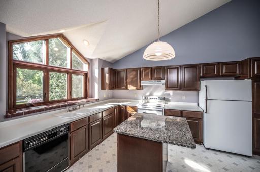 What a beautiful kitchen! Vaulted ceiling carry throughout the main level and allows for this lovely kitchen window to let a ton of light in! Granite topped center island with room for two stools. Cherry cabinetry.