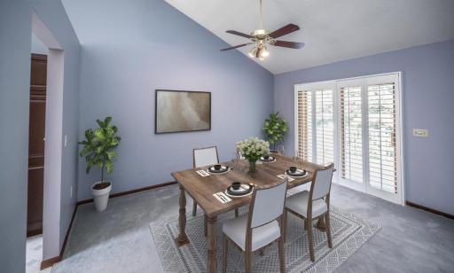 Virtually staged dining room. Wide sliding glass door with plantation shutters open to the two level deck and backyard.